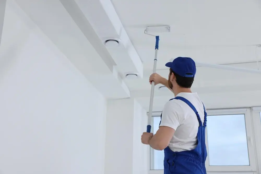 Malermeister streicht Decke